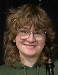 A person with long hair wearing glasses

AI-generated content may be incorrect.